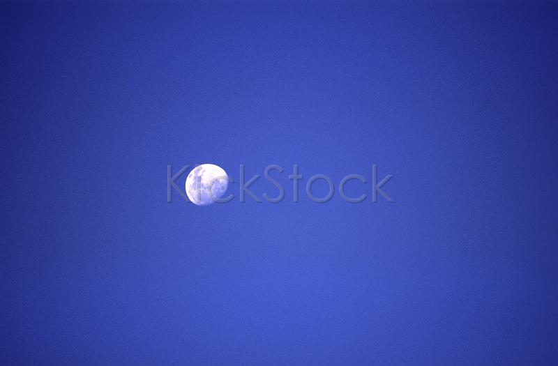 an almost full moon on a twilight sky