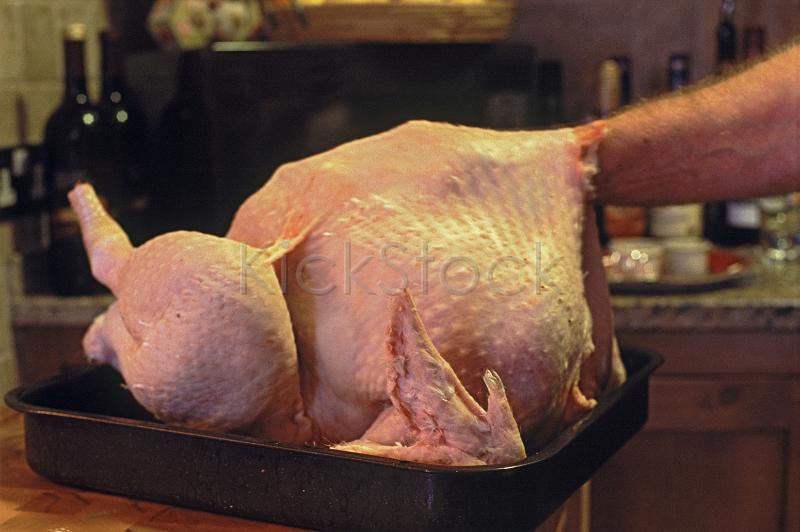 a hand stuffing a turkey